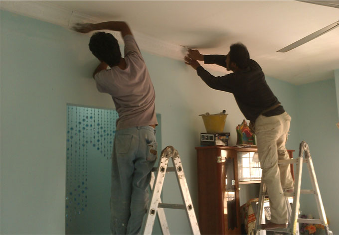 Artisans r&eacute;novant un plafond en pl&acirc;tre.
